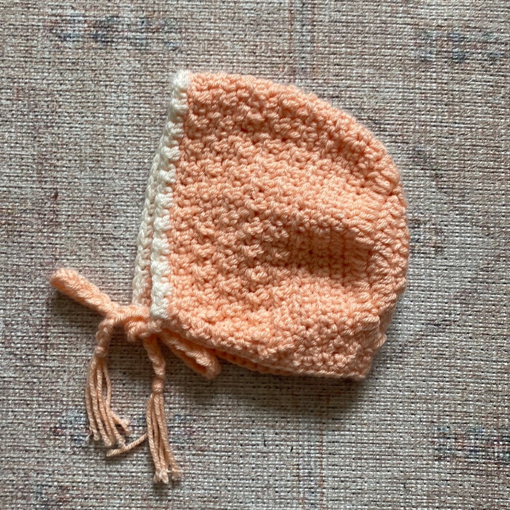 Hand crocheted bonnet, peach and cream colors.